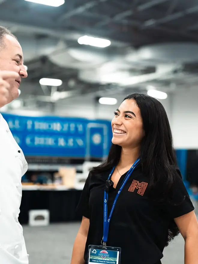 Maze Marketing team member talking with a chef at the Maximum Quality Foods food show